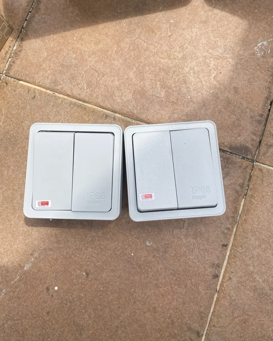 Two IP66-rated weatherproof light switches before installation in Singapore