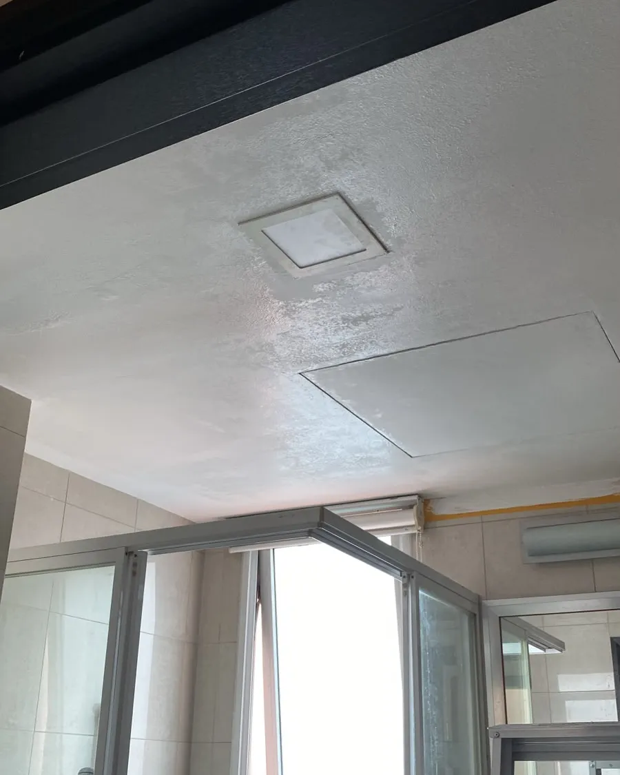 Freshly repainted toilet ceiling around an extractor vent in a Singapore flat